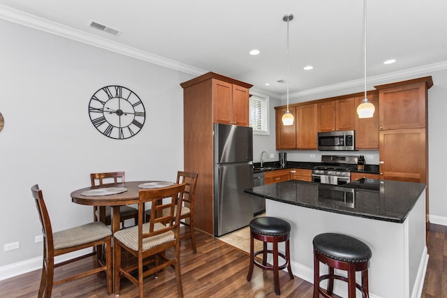 3938 N Southport Ave Unit G, Chicago, IL 60613 - kitchen with stainless steel appliances, dark wood-style flooring, ornamental molding, brown cabinets, and hanging light fixtures