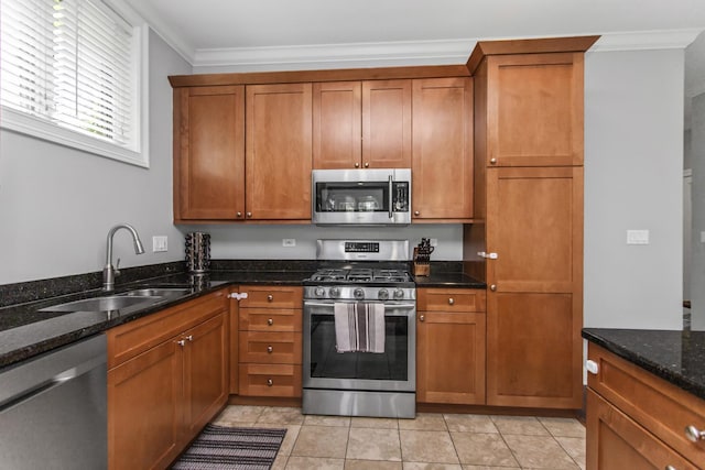 3938 N Southport Ave Unit G, Chicago, IL 60613 - kitchen featuring appliances with stainless steel finishes, brown cabinetry, ornamental molding, and dark stone counters