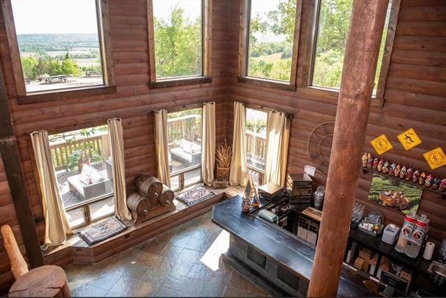 2003 W Hanover Rd, Hanover, IL 61041 - living room featuring log walls, stone tile flooring, and a high ceiling