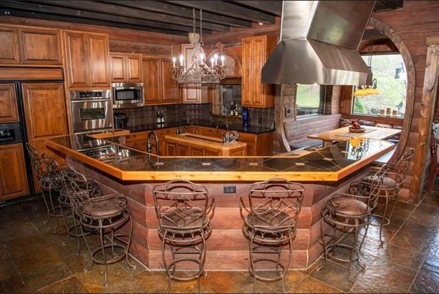 2003 W Hanover Rd, Hanover, IL 61041 - kitchen featuring island range hood, brown cabinetry, stainless steel microwave, paneled built in fridge, and a kitchen island