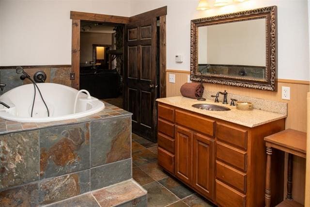 2003 W Hanover Rd, Hanover, IL 61041 - bathroom featuring a wainscoted wall, a garden tub, vanity, and stone finish flooring
