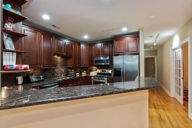 453 N May St Unit Gs, Chicago, IL 60642 - kitchen featuring stainless steel appliances, open shelves, dark stone countertops, light wood-type flooring, and dark brown cabinets