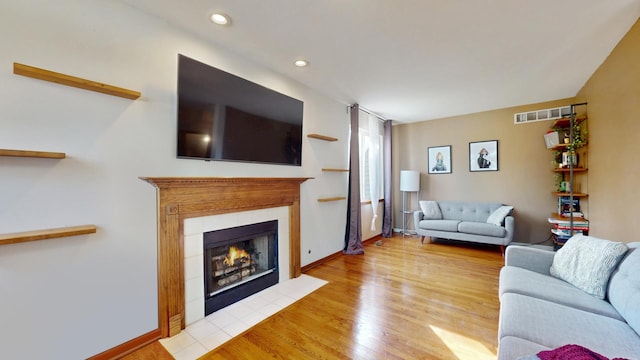 1389 Lily Cache Ln, Bolingbrook, IL 60490 - living area featuring a tiled fireplace, wood finished floors, and recessed lighting