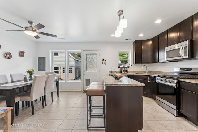 1828 Hovland Ct, Evanston, IL 60201 - kitchen with appliances with stainless steel finishes, light tile patterned floors, dark brown cabinets, a center island, and recessed lighting