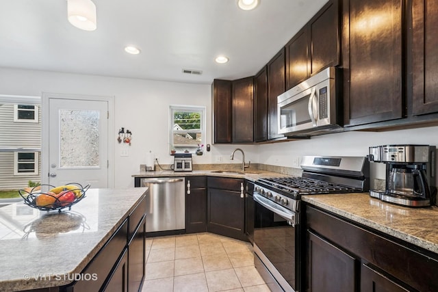 1828 Hovland Ct, Evanston, IL 60201 - kitchen with appliances with stainless steel finishes, dark brown cabinets, light tile patterned floors, recessed lighting, and light stone counters