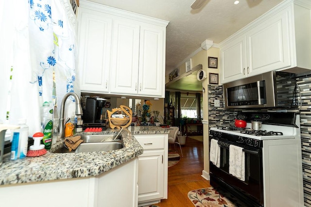 8805 S California Ave, Evergreen Park, IL 60805 - kitchen with black range with gas stovetop, stainless steel microwave, decorative backsplash, white cabinetry, and a textured ceiling