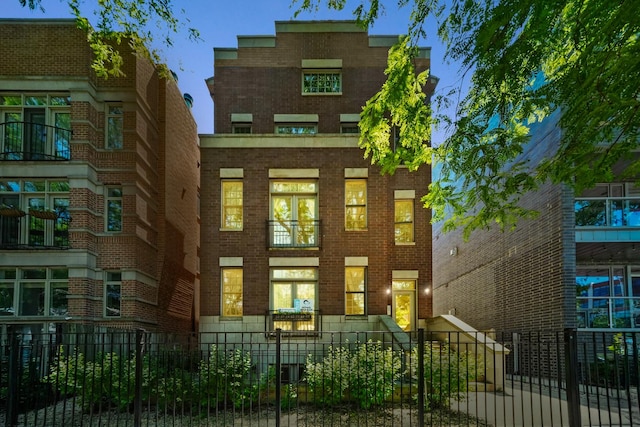 1749 W Roscoe St Unit 1, Chicago, IL 60657 - view of front facade with a fenced front yard and brick siding