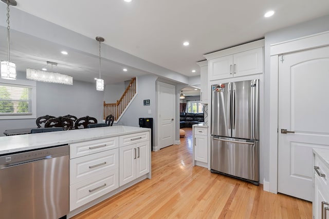 8313 W Ballard Rd, Niles, IL 60714 - kitchen featuring appliances with stainless steel finishes, light wood-style floors, recessed lighting, white cabinets, and pendant lighting
