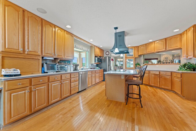 1422 Pier Dr, Lake Summerset, IL 61019 - kitchen featuring appliances with stainless steel finishes, a kitchen bar, light wood finished floors, decorative light fixtures, and a center island