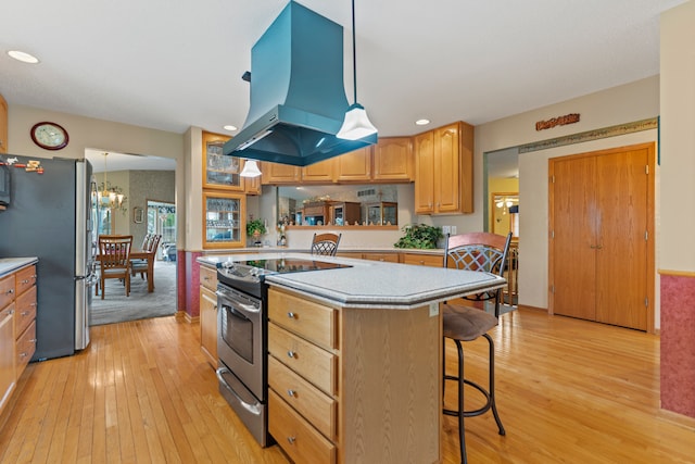 1422 Pier Dr, Lake Summerset, IL 61019 - kitchen with stainless steel appliances, island exhaust hood, light wood-style floors, a kitchen bar, and light countertops
