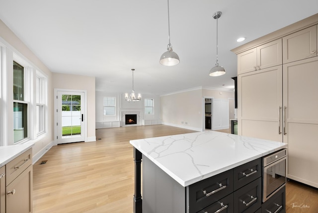 4508 Stonewall Ave, Downers Grove, IL 60515 - kitchen with light wood finished floors, crown molding, decorative light fixtures, a lit fireplace, and a center island