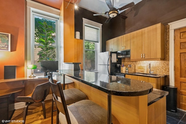 909 W Wisconsin St Unit 1M, Chicago, IL 60614 - kitchen featuring stainless steel appliances, tasteful backsplash, dark stone counters, an office area, and ceiling fan
