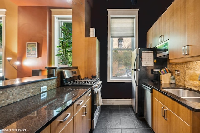 909 W Wisconsin St Unit 1M, Chicago, IL 60614 - kitchen with stainless steel appliances, backsplash, dark stone countertops, and brown cabinetry