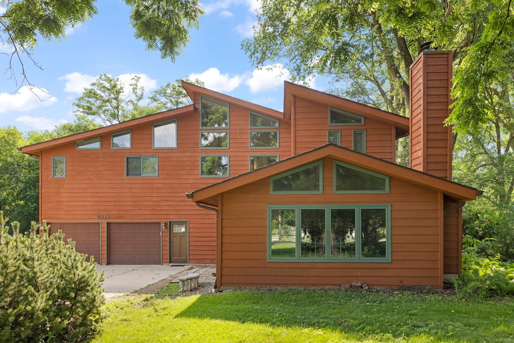 5316 Fairview Ave, Downers Grove, IL 60515 - rear view of house with a chimney, an attached garage, a yard, and driveway