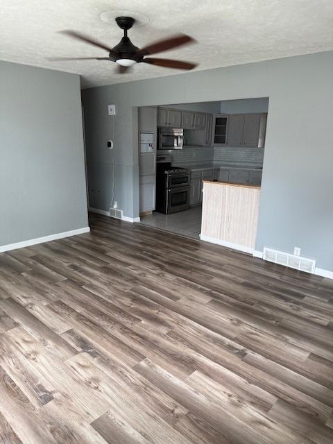 4714 Pine Al St, Machesney Park, IL 61115 - unfurnished living room featuring a ceiling fan, dark wood-style flooring, and a textured ceiling