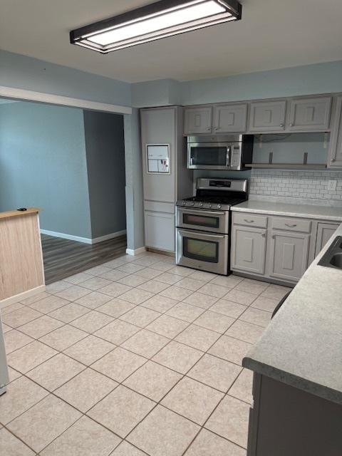 4714 Pine Al St, Machesney Park, IL 61115 - kitchen featuring appliances with stainless steel finishes, gray cabinetry, and light tile patterned floors