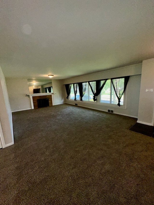 207 Dodge Ave, Danville, IL 61832 - unfurnished living room featuring dark carpet, a fireplace, and a textured ceiling