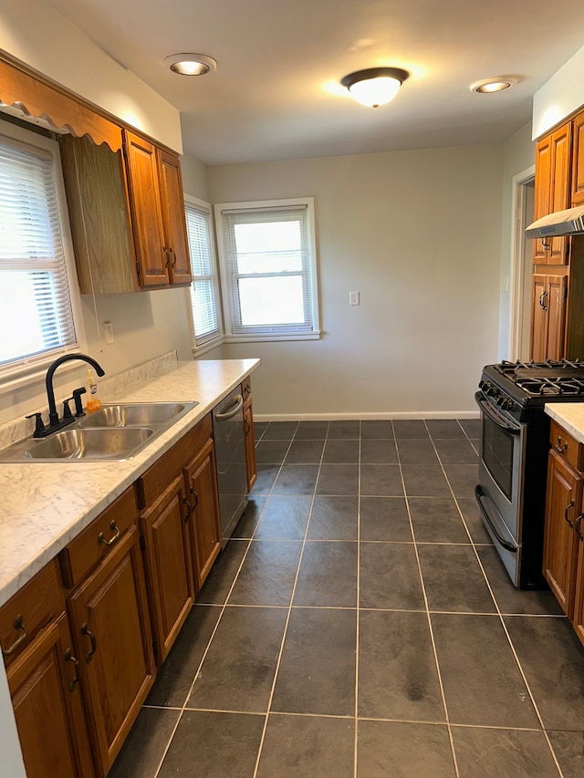 207 Dodge Ave, Danville, IL 61832 - kitchen featuring appliances with stainless steel finishes, brown cabinetry, dark tile patterned flooring, light countertops, and recessed lighting