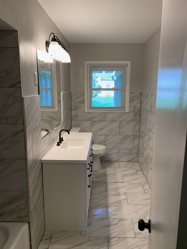 207 Dodge Ave, Danville, IL 61832 - bathroom with vanity, marble look tiles, tile walls, and a wainscoted wall