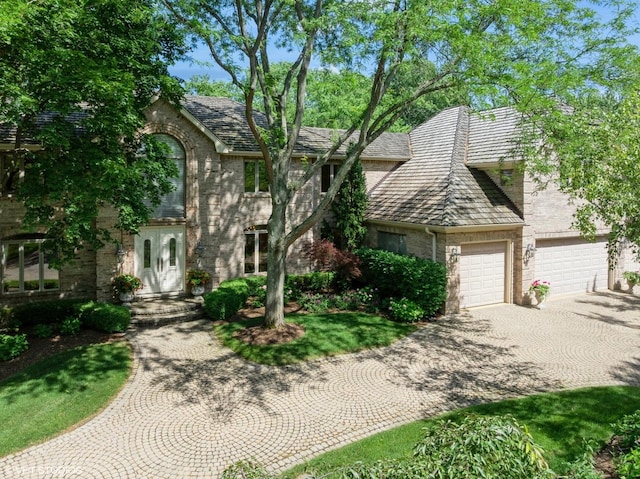 85 Ela Rd, Inverness, IL 60067 - view of front of house with driveway, brick siding, and a garage