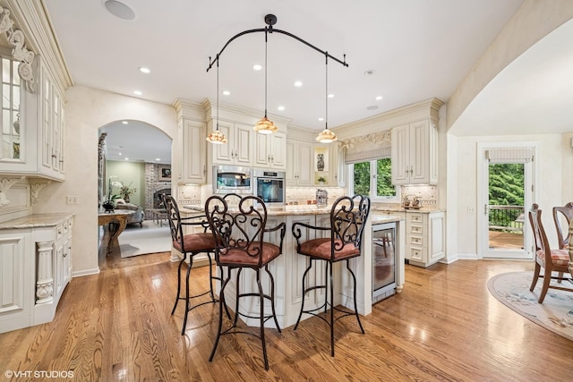 85 Ela Rd, Inverness, IL 60067 - kitchen with appliances with stainless steel finishes, arched walkways, light stone countertops, light wood-style flooring, and recessed lighting