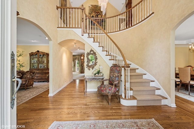 85 Ela Rd, Inverness, IL 60067 - foyer featuring stairs, wood finished floors, a high ceiling, a chandelier, and arched walkways