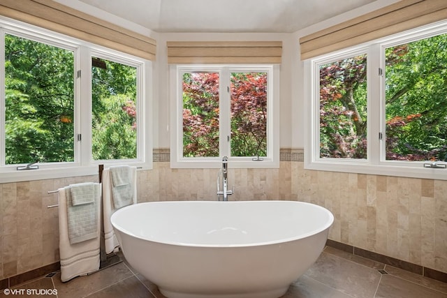 85 Ela Rd, Inverness, IL 60067 - bathroom featuring tile walls, a freestanding tub, healthy amount of natural light, wainscoting, and tile patterned flooring