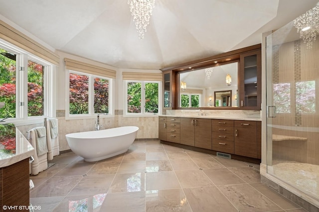 85 Ela Rd, Inverness, IL 60067 - full bathroom with vaulted ceiling, vanity, a freestanding tub, a shower stall, and tile walls