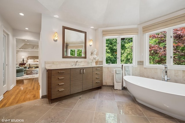 85 Ela Rd, Inverness, IL 60067 - bathroom with vanity, a freestanding bath, tile patterned flooring, recessed lighting, and tile walls