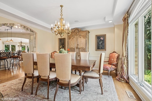 85 Ela Rd, Inverness, IL 60067 - dining area featuring a chandelier, a tray ceiling, light wood finished floors, healthy amount of natural light, and crown molding