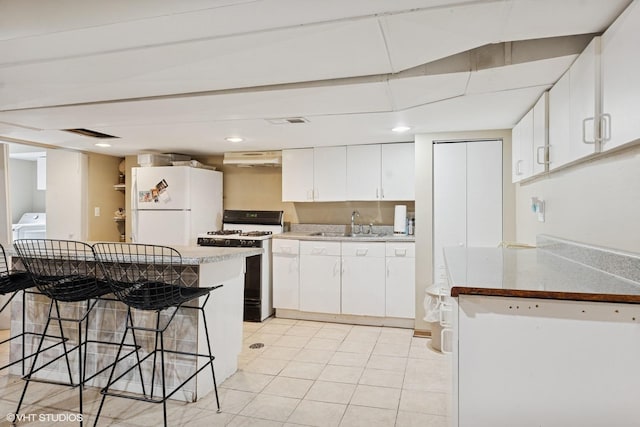 8437 167th St, Tinley Park, IL 60487 - kitchen with white appliances, a breakfast bar, white cabinetry, light tile patterned floors, and under cabinet range hood