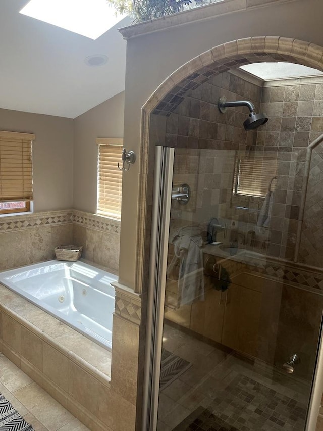 1620 S 5th Ave, Kankakee, IL 60901 - bathroom featuring tile patterned floors, a tub with jets, a shower stall, lofted ceiling, and a skylight