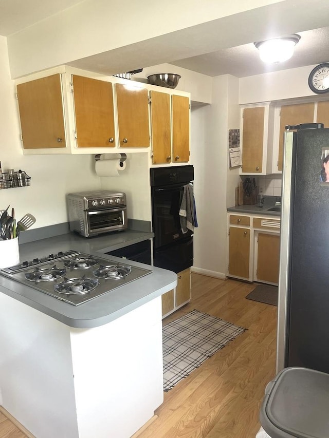 1620 S 5th Ave, Kankakee, IL 60901 - kitchen featuring appliances with stainless steel finishes, light wood finished floors, a peninsula, and a warming drawer