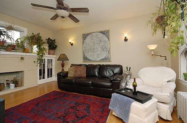 3135 W Leland Ave Unit 3W, Chicago, IL 60625 - living area featuring radiator, wood finished floors, a ceiling fan, and a fireplace with flush hearth