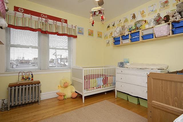 3135 W Leland Ave Unit 3W, Chicago, IL 60625 - bedroom featuring multiple windows, wood finished floors, and radiator heating unit
