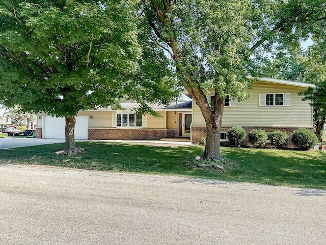 202 E 8th St, Gridley, IL 61744 - split level home with brick siding, concrete driveway, an attached garage, and a front lawn
