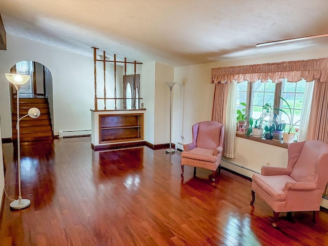 202 E 8th St, Gridley, IL 61744 - living area with a baseboard radiator, wood-type flooring, and arched walkways