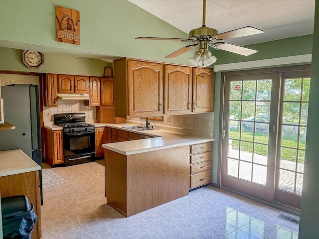 202 E 8th St, Gridley, IL 61744 - kitchen featuring black range with gas stovetop, under cabinet range hood, freestanding refrigerator, a peninsula, and plenty of natural light