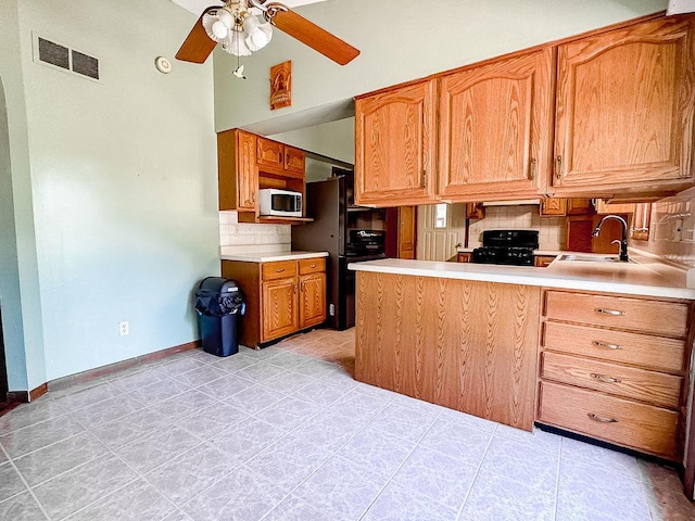 202 E 8th St, Gridley, IL 61744 - kitchen with white microwave, tasteful backsplash, a ceiling fan, light countertops, and light tile patterned flooring