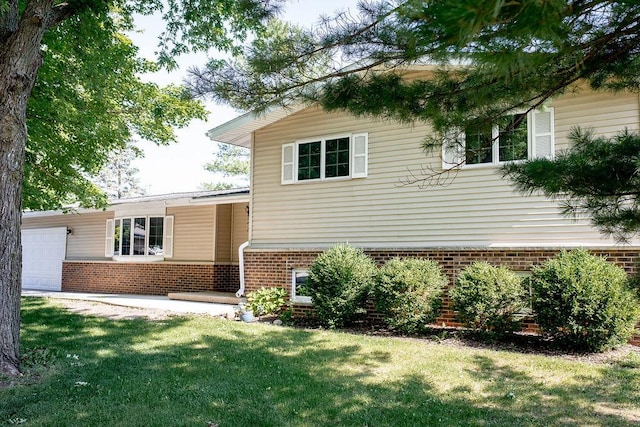 202 E 8th St, Gridley, IL 61744 - tri-level home with brick siding, a garage, and a front yard