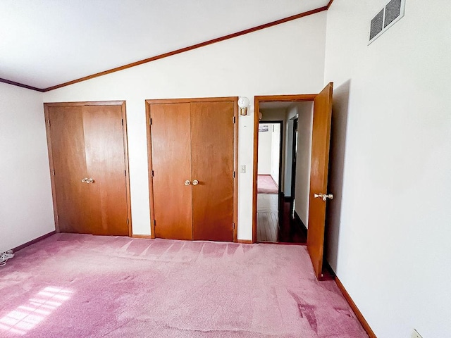 202 E 8th St, Gridley, IL 61744 - unfurnished bedroom with lofted ceiling, multiple closets, carpet flooring, and ornamental molding