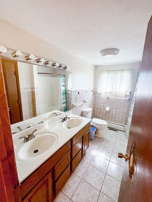 202 E 8th St, Gridley, IL 61744 - bathroom featuring tile walls, tile patterned floors, double vanity, baseboard heating, and a shower with curtain