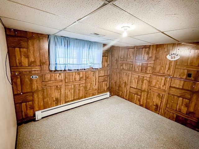 202 E 8th St, Gridley, IL 61744 - basement featuring a baseboard radiator, wood walls, carpet floors, and a paneled ceiling