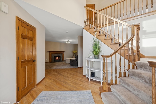1177 Dovercliff Way, Crystal Lake, IL 60014 - stairs featuring wood finished floors, a high ceiling, and a lit fireplace