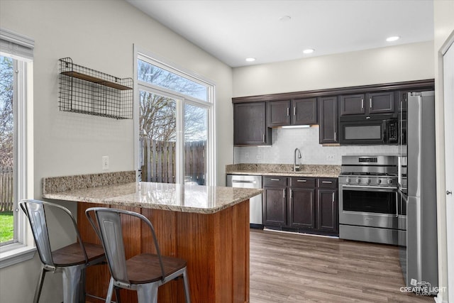 307 Gregory Ln, Plano, IL 60545 - kitchen with appliances with stainless steel finishes, plenty of natural light, light stone countertops, a peninsula, and recessed lighting