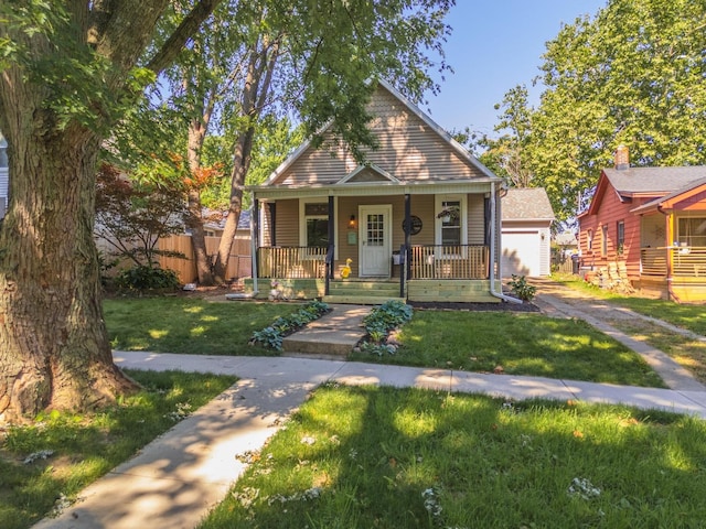 1404 Fell Ave, Bloomington, IL 61701 - bungalow-style house featuring covered porch, a front lawn, and a garage