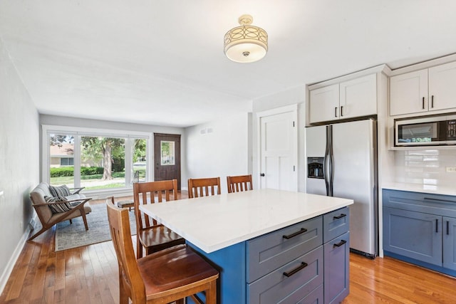 105 E Vermont St, Villa Park, IL 60181 - kitchen with stainless steel appliances, a breakfast bar, light wood finished floors, and light countertops
