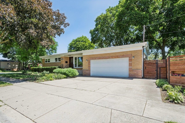 105 E Vermont St, Villa Park, IL 60181 - view of front of home featuring an attached garage, a gate, brick siding, and concrete driveway