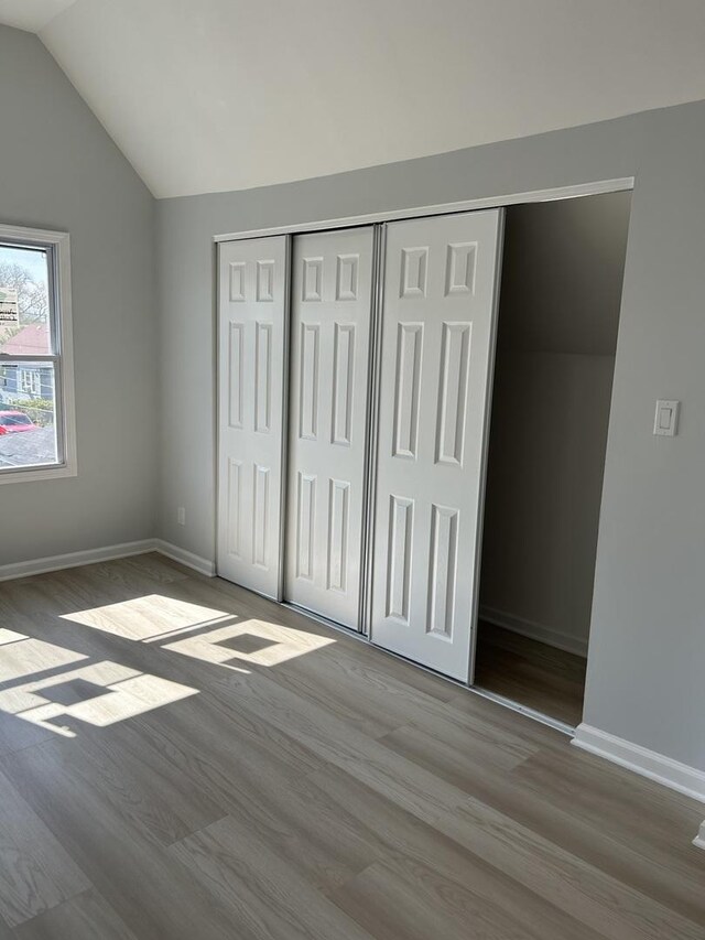 1122 N Mason Ave, Chicago, IL 60651 - unfurnished bedroom featuring wood finished floors, a closet, and vaulted ceiling