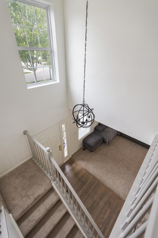 9312 Bristol Ln, Huntley, IL 60142 - staircase featuring wood finished floors, a chandelier, and carpet